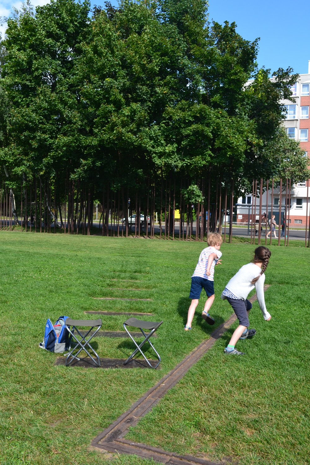 Zwei Kinder laufen über eine Wiese im Park